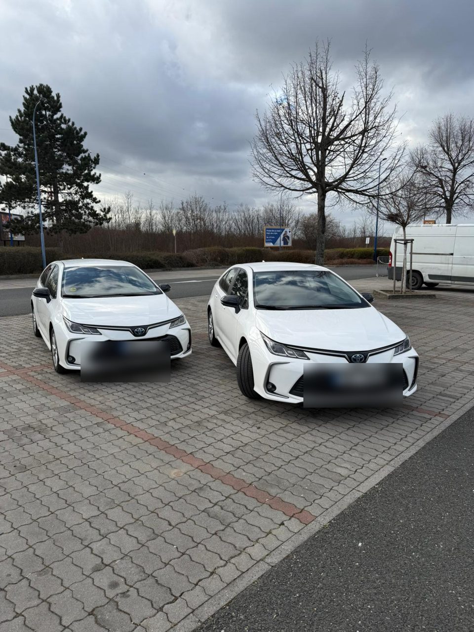 Two white Toyota Corolla Hybrid sedans of the Svaggy Fleet parked side by side