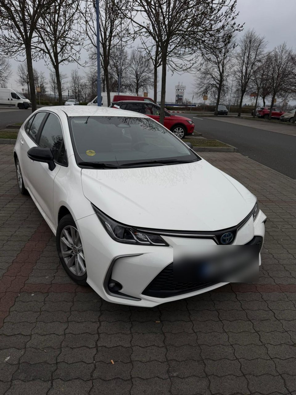 White Toyota Corolla Hybrid, front three-quarter view